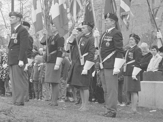 remembrance day image. Men and women in uniform with flags.